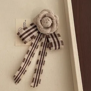 Spilla camelia in tessuto beige retrò con nastri a righe marroni per accessori donna