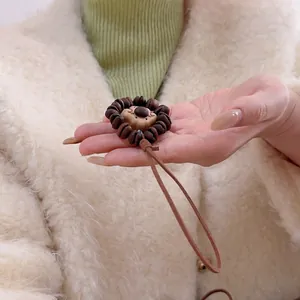 Detailed close-up of a hand-carved peach wood lion pendant with coffee bean hair detail