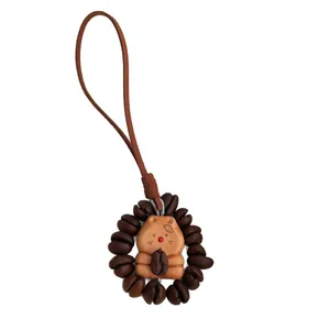 Natural peach wood Capybara charm with coffee bean accents on a long brown lanyard