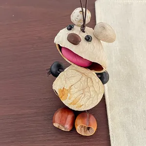 Macro view of a handmade nut shell mouse pendant with natural textures and red seed accent