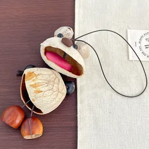 Handmade creative walnut shell bear charm with chestnut feet on a rustic background