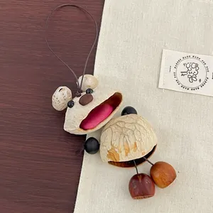 Handmade creative bear charm crafted from natural nutshells and seeds with a brown cord