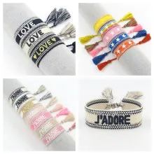 Detalle de pulseras de la amistad tejidas con letras LOVE bordadas y borlas