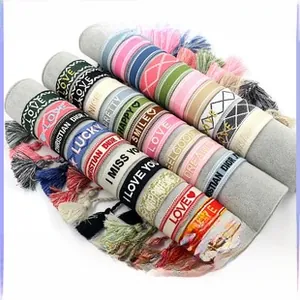 Vista macro di braccialetti con nappe ricamati con motivi geometrici tessuti