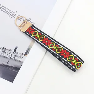 Llavero de pulsera étnico bordado con motivos geométricos y cierre de metal dorado brillante