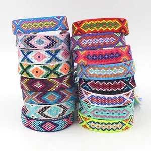 Stacked handmade woven friendship bracelets with vibrant bohemian geometric patterns