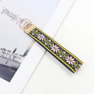 Llavero de estilo étnico tejido con bordado floral rosa y anillo dorado