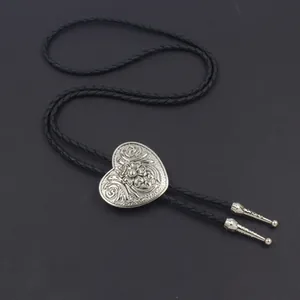 Dettaglio del bolo tie a cuore argento con incisioni floreali e cordino intrecciato