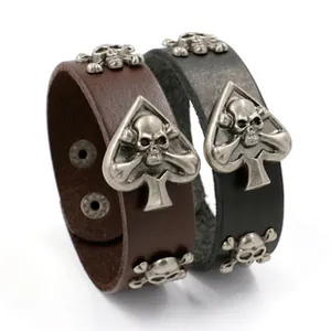 Macro detail of punk leather bracelets with skull charms and metallic spade buckle clasp
