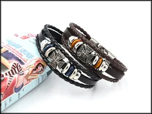 Vue détaillée des pendentifs croix punk sur des bracelets en cuir tressé multicouche