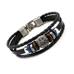 Close-up of multilayer leather bracelet with heraldic eagle metal charm and vintage beads