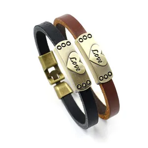 Détail de bracelets en cuir avec plaques cœur Love dorées en noir et marron