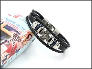 Gros plan d'un bracelet en cuir punk avec une médaille croix rétro et anneaux en métal