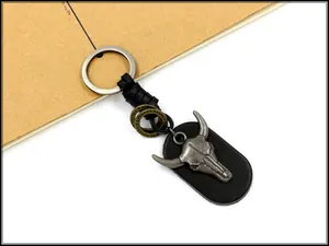 Detailed macro view of retro bull skull pendant with leather base on metal keychain