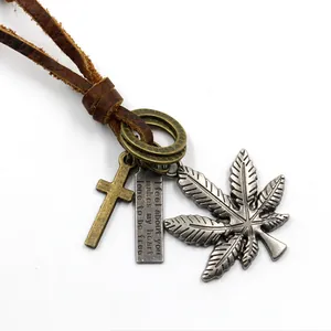 Collana vintage in pelle con croce bronzo, targa incisa e foglia su sfondo bianco