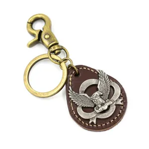 Detail of vintage leather keychain featuring bronze eagle emblem and metal lobster clasp