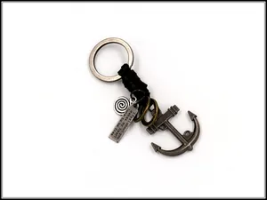 Detail of vintage anchor keychain with engraved metal tag and braided leather cord