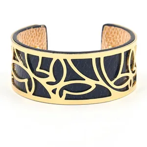 Detailed view of the gold hollow butterfly pattern on the navy blue leather cuff bracelet