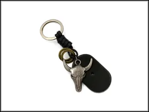 Detailed macro of a vintage silver bull skull pendant with black leather keychain accents
