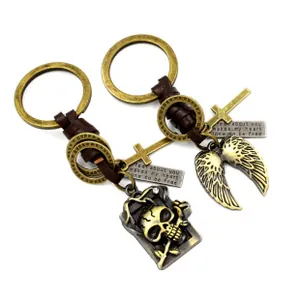 Detail of vintage leather braided keychains with bronze skull, wing and cross charms