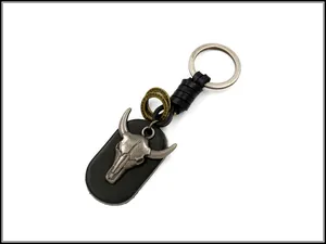Detail view of punk bull head skull alloy emblem on vintage black leather keychain