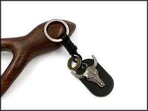 Detail of retro punk bull skull keychain with black leather base and vintage metal ring