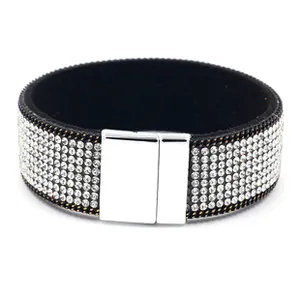 Détail macro d'un bracelet large en cuir PU avec fermoir magnétique argenté et strass