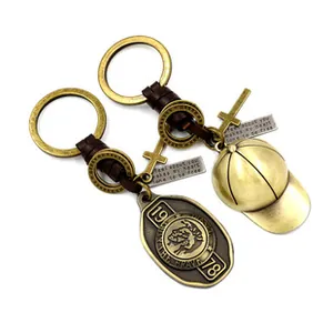 Detail of vintage brass keychains featuring Indian head medallion and cross pendant