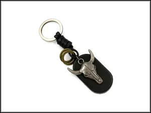 Detail of retro punk bull skull pendant with leather oval tag on a silver keychain