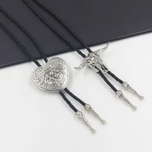 Dettaglio di cravatte bolo vintage con pendenti a cuore e teschio di toro e cordino nero