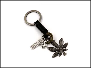 Detail of vintage braided leather keychain with maple leaf and crescent moon alloy pendants