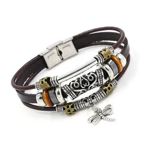 Dettaglio del bracciale multistrato in pelle con ciondolo a libellula e perline in metallo