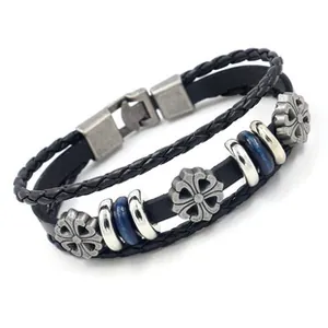 Detail of multi-layer black leather bracelet with silver cross charms and blue beads