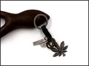 Macro view of vintage alloy maple leaf and leather braided keychain with metal charms