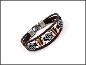 Close-up of vintage multi-layer brown leather bracelet with silver dollar sign charms