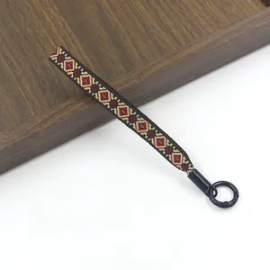 Detail van de bohemien geweven polsband met een zwarte ronde veerring sluiting