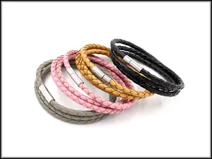 Detail van meerlaagse leren armbanden in grijs, roze, geel en zwart met een magnetische sluiting