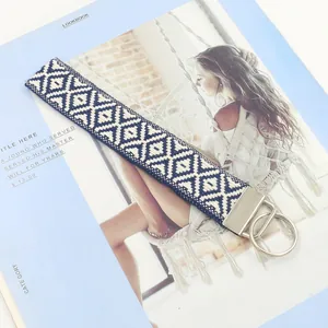 Llavero de pulsera tejido a mano con patrones geométricos azul marino sobre una revista