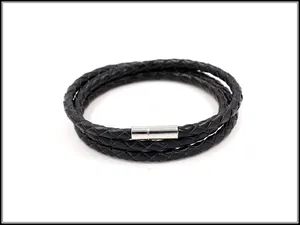 Detail van een zwarte gevlochten leren armband met een zilveren magnetische sluiting