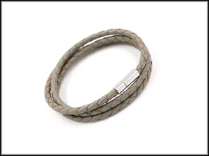 Macro-opname van grijze gevlochten leren armband met zilveren magnetische metalen sluiting