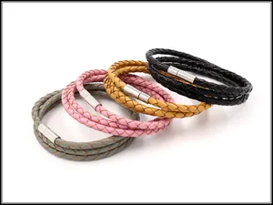 Detail van meerlaagse gevlochten leren armbanden in grijs, roze, geel en zwart