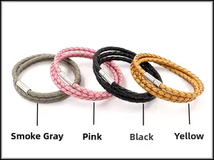 Detail van gevlochten leren armbanden in rookgrijs, roze, zwart en geel met metalen sluiting