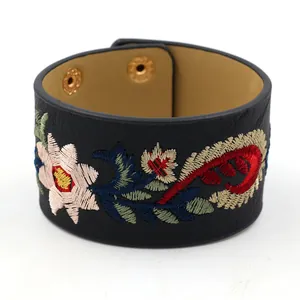Bracelet manchette large en similicuir noir avec broderie florale et fermoirs à pression