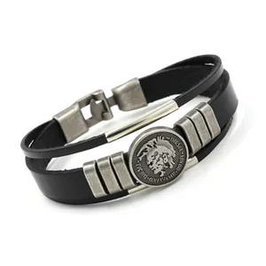 Dettaglio del bracciale multistrato in pelle con emblema vintage e chiusura in metallo