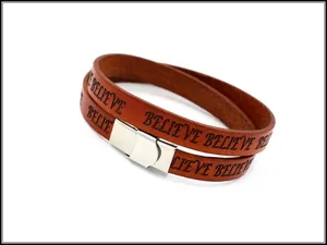 Detail of brown double-wrap leather bracelet with laser-engraved BELIEVE text and silver clasp