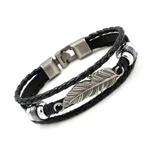 Detailed view of multilayer leather bracelet featuring a silver metal feather pendant