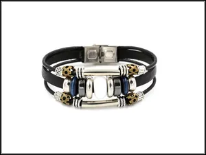 Dettaglio di un bracciale multistrato in pelle con occhio di gatto bianco e chiusura