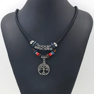Detail of tree of life pendant with colorful beads on black woven necklace cord