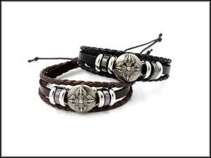 Detail von mehrlagigen Lederarmbändern mit silbernen religiösen Vajra-Anhängern