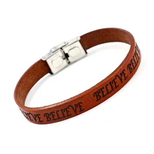 Brown leather bracelet with BELIEVE engraving and silver metal buckle on white background